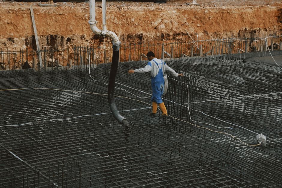 profesjonalna ekipa wylewa beton z gruszki bezpośrednio do szalunków fundamentowych
