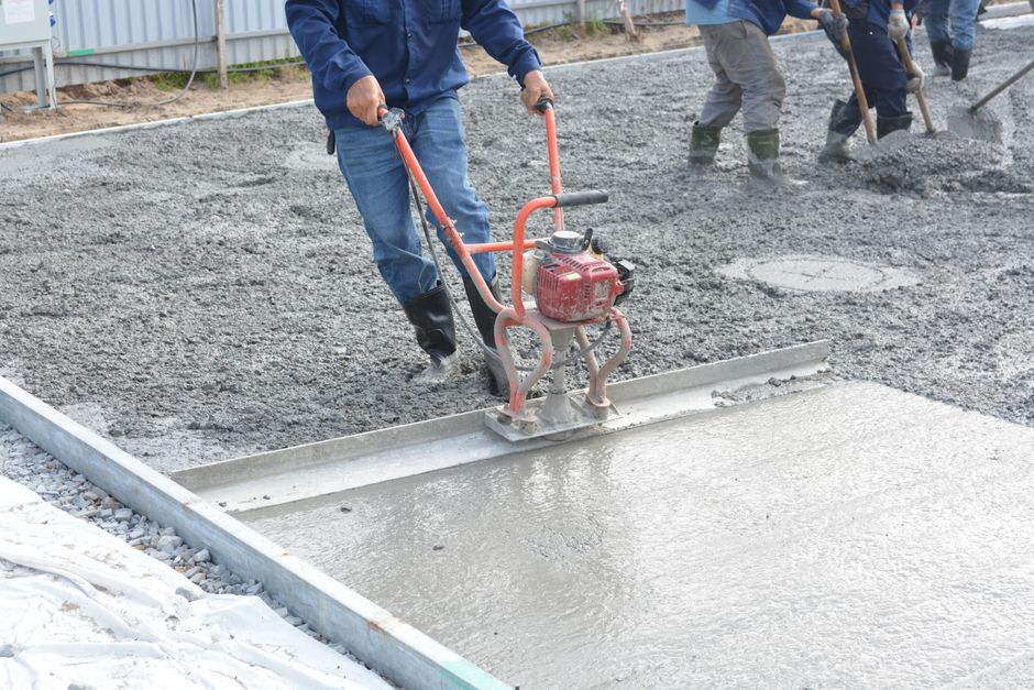 robotnik budowlany wylewający beton na budowie w zimowych warunkach przy zachowaniu rygorów bezpieczeństwa